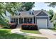Charming, blue-gray two-story home with a well-manicured front yard and attached one-car garage at 604 Mills St, Raleigh, NC 27608