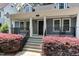 Front porch of this home is adorned with manicured shrubbery and a porch swing at 604 Mills St, Raleigh, NC 27608