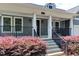 Inviting front porch with porch swing with lush landscaping and stairs at 604 Mills St, Raleigh, NC 27608