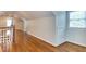 Hallway featuring hardwood floors, white trim, and access to multiple rooms and closets at 604 Mills St, Raleigh, NC 27608