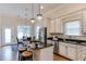 Bright kitchen featuring white cabinets, granite countertops, an island with seating, and stainless steel appliances at 604 Mills St, Raleigh, NC 27608