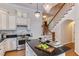 Charming kitchen with white cabinets, a black countertop island, chandeliers, and hardwood floors at 604 Mills St, Raleigh, NC 27608