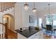 Kitchen features a black granite countertop island, chandeliers and a view to the breakfast nook and hardwood floors at 604 Mills St, Raleigh, NC 27608