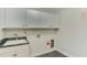Functional laundry room with a utility sink, storage cabinets, and tile floor at 604 Mills St, Raleigh, NC 27608