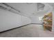Spacious basement with painted concrete walls and floors, exposed ductwork, and shelving units for organized storage at 722 Baker St, Oxford, NC 27565