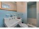 Bathroom featuring a blue-tiled shower, unique blue fixtures and a large, ornate mirror at 722 Baker St, Oxford, NC 27565