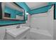 Classic bathroom featuring blue walls, a vintage vanity, and a clean, white-tiled tub with shower at 722 Baker St, Oxford, NC 27565