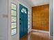 Entryway featuring a blue front door with decorative windows, tile flooring, and wood paneled wall at 722 Baker St, Oxford, NC 27565