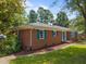 Side view of a brick home featuring well-maintained landscaping, and attractive blue shutters at 722 Baker St, Oxford, NC 27565
