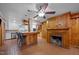 Combined kitchen and living space with a brick fireplace, kitchen island, and wood paneling for a rustic design at 722 Baker St, Oxford, NC 27565