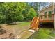 Backyard with deck, stairs, mature trees, and green grass, a serene outdoor space at 724 Piermont Dr, Cary, NC 27519
