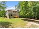 Exterior rear view of home shows a deck, manicured landscaping, mature trees, and neutral siding at 724 Piermont Dr, Cary, NC 27519