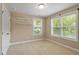 Well-lit bedroom with natural light, neutral walls, plush carpet, and built-in shelving at 724 Piermont Dr, Cary, NC 27519