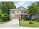 Charming two-story home featuring tan siding, brick accents, a well-manicured lawn, and an attached two-car garage at 724 Piermont Dr, Cary, NC 27519