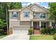 Charming two-story home featuring tan siding, brick accents, a well-manicured lawn, and an attached two-car garage at 724 Piermont Dr, Cary, NC 27519