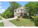 Charming two-story home featuring tan siding, brick accents, a well-manicured lawn, and an attached two-car garage at 724 Piermont Dr, Cary, NC 27519