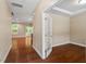 Bright hallway with hardwood floors, a glass door office entrance, and views into the living area and outdoor greenery at 724 Piermont Dr, Cary, NC 27519