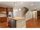 An island and stainless steel refrigerator are visible in this kitchen with hardwood floors and open floor plan at 724 Piermont Dr, Cary, NC 27519