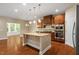 Modern kitchen with stainless steel appliances, granite countertops, an island, and hardwood floors, with a view to the living area at 724 Piermont Dr, Cary, NC 27519