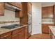 Close-up view of the kitchen, including granite countertops, wooden cabinets, stainless steel appliances, and modern tile backsplash at 724 Piermont Dr, Cary, NC 27519