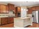 Well-equipped kitchen features stainless steel appliances, granite countertops, an island, and wooden cabinetry at 724 Piermont Dr, Cary, NC 27519