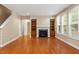 Living room with hardwood floors, fireplace, built-in shelves, and large windows at 724 Piermont Dr, Cary, NC 27519