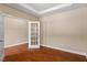 Bright home office featuring hardwood floors, neutral walls, a tray ceiling, and a glass french door entrance at 724 Piermont Dr, Cary, NC 27519