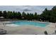 Community pool surrounded by lounge chairs, landscaping and a fenced-in area at 724 Piermont Dr, Cary, NC 27519