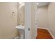 Powder room with pedestal sink, framed mirror, hardwood floors, and crisp, neutral paint at 724 Piermont Dr, Cary, NC 27519