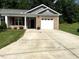 Charming single-story home with a brick facade, white garage door, and well-maintained landscaping at 820 Houston Ct, Haw River, NC 27258