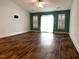 Spacious living room featuring hardwood floors, large windows, and a modern ceiling fan at 820 Houston Ct, Haw River, NC 27258