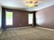 Large primary bedroom with plush carpet, two windows, and neutral-toned walls at 820 Houston Ct, Haw River, NC 27258