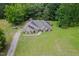 An aerial view of a well-maintained brick home showcasing its large yard, mature trees, and private setting at 8917 Thompson Mill Rd, Wake Forest, NC 27587