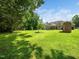 Lush backyard showcasing green grass, mature trees, and a view of the home's rear facade at 8917 Thompson Mill Rd, Wake Forest, NC 27587