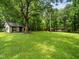 Large grassy backyard with mature trees and outbuildings at 8917 Thompson Mill Rd, Wake Forest, NC 27587