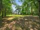 Sprawling backyard featuring mature trees and ample green space with a long view of the house in the distance at 8917 Thompson Mill Rd, Wake Forest, NC 27587