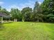 Expansive green backyard featuring a utility shed, mature trees, and ample space for activities at 8917 Thompson Mill Rd, Wake Forest, NC 27587