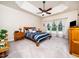 Inviting bedroom features tray ceilings, a ceiling fan, and an array of windows with natural light at 8917 Thompson Mill Rd, Wake Forest, NC 27587