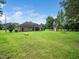 Back exterior of home features a covered patio, lush backyard, and utility shed at 8917 Thompson Mill Rd, Wake Forest, NC 27587