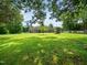 Exterior view of the home features a large grassy lawn, outbuildings and mature trees at 8917 Thompson Mill Rd, Wake Forest, NC 27587