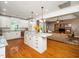 Open kitchen with island and view into living room, showcasing hardwood floors and modern cabinetry at 8917 Thompson Mill Rd, Wake Forest, NC 27587