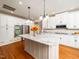 Spacious white kitchen featuring a large island with granite countertops and stainless steel appliances at 8917 Thompson Mill Rd, Wake Forest, NC 27587