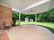 Covered patio area with a ceiling fan and seating overlooking a lush backyard and utility shed at 8917 Thompson Mill Rd, Wake Forest, NC 27587