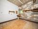 A small unfinished room with tiled floors, sink, block wall, and a window at 8917 Thompson Mill Rd, Wake Forest, NC 27587