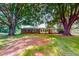 Spacious backyard with mature trees, a well-maintained lawn, and a charming brick home at 9455 Boston Rd, Roxboro, NC 27574