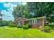 Well-kept brick home with green shutters, a manicured lawn, and mature landscaping at 9455 Boston Rd, Roxboro, NC 27574