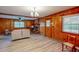 Bright living room features wood paneling, updated flooring, and a brick fireplace at 9455 Boston Rd, Roxboro, NC 27574