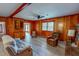Comfortable living room with wood paneling, a fireplace, ceiling fan, and laminate flooring at 9455 Boston Rd, Roxboro, NC 27574
