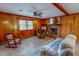 Cozy living room features wood paneling, brick fireplace, ceiling fan, and plush sofa at 9455 Boston Rd, Roxboro, NC 27574