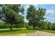 Scenic view of a green field with trees and a winding road, highlighting the natural beauty of the area at 9455 Boston Rd, Roxboro, NC 27574